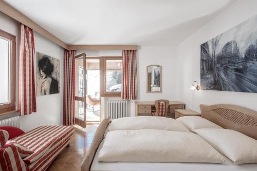 a bedroom with a large bed and a window at ARTEFUGIUM panoramico in Selva di Val Gardena
