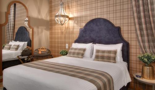 a bedroom with a large white bed with a blue headboard at Frontzu Politia in Ioannina