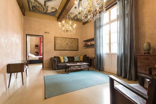 salon z kanapą i żyrandolem w obiekcie Domus Aurea w mieście Carpi