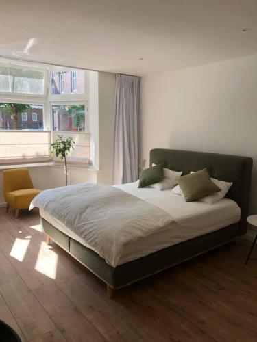 a bedroom with a large bed and a window at Huize Hoge Fronten in Maastricht