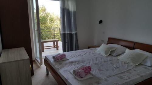 Un dormitorio con una cama con almohadas rosas. en Holiday House Maretta - Apartment No 1, en Lukovo Šugarje