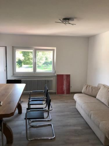 uma sala de estar com um sofá e duas cadeiras em Ferienwohnung Albblick 3 Münsingen em Münsingen