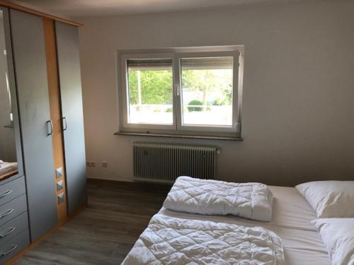 um quarto com 2 camas e uma janela em Ferienwohnung Albblick 3 Münsingen em Münsingen
