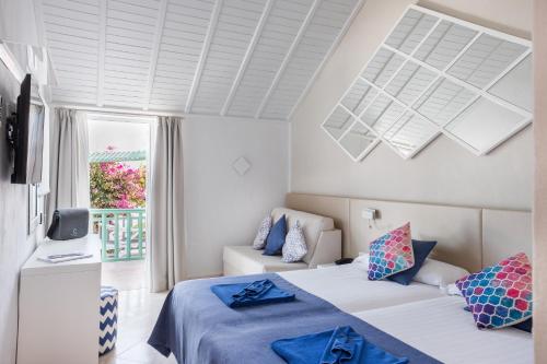 a white room with two beds and a couch at Aldiana Club Fuerteventura in Morro del Jable