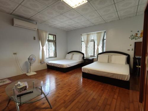 1 dormitorio con 2 camas y suelo de madera en Xiao Guilin Homestay en Changbin