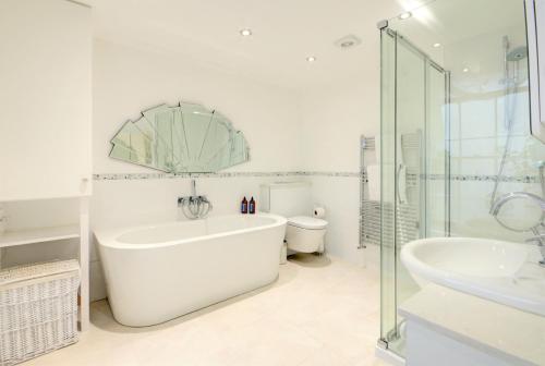a white bathroom with a tub and a sink at Luxury Apartments - 39 Rodney Road Apartment in Cheltenham