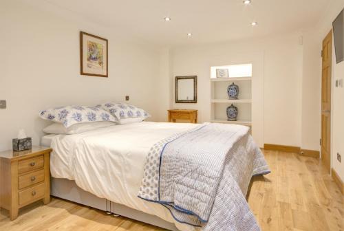 um quarto com uma cama branca e almofadas azuis em Luxury Apartments - 39 Rodney Road Apartment em Cheltenham