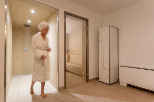 Ein Mann im Bademantel steht im Badezimmer in der Unterkunft Hotel Las Arenas in Can Pastilla
