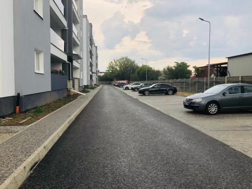an empty parking lot with cars parked next to a building at Roxi's Apartment in Sibiu