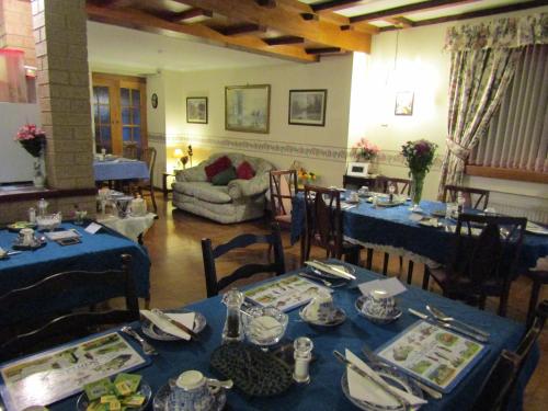 uma sala de jantar com mesas e cadeiras azuis em Sunnyside B&B em Balloch