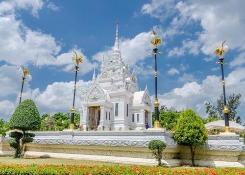 Un tempio bianco con una torre sopra. di The Port Hostel a Suratthani