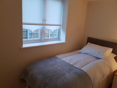 a bed in a room with a window at Pinfold Court Apartments in Knowsley