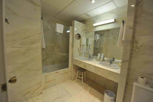 La grande salle de bains est pourvue d'un lavabo et d'une douche. dans l'établissement Puerta de Segovia, à La Lastrilla