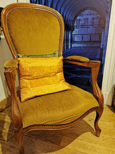 a wooden chair with a yellow pillow on it at Château de Verdalle in Verdalle