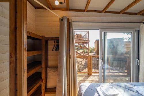 a bedroom with a bunk bed and a balcony at Viglamo Domaine Presqu'île de La Franqui in Leucate