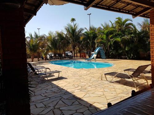 una piscina con un tobogán en un complejo en Pousada Sol Nascente ll, en Olímpia