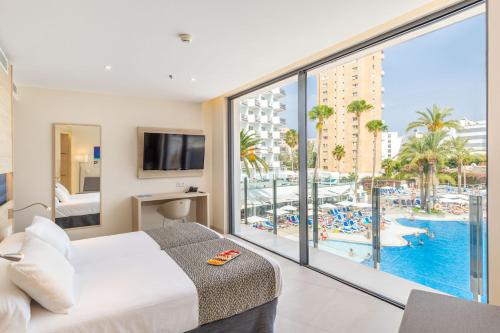 a bedroom with a bed and a view of a pool at Hotel Samos in Magaluf