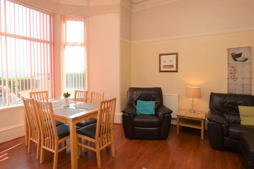 a living room with a table and chairs at Sebright Holiday Apartment in Dunoon