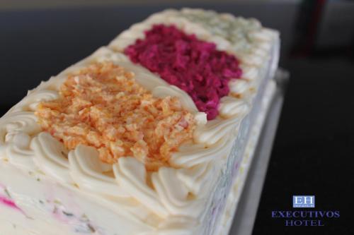 a cake with white frosting and pink crystals on it at Executivos Hotel in Cruz Alta