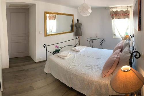 - une chambre avec un lit, un miroir et une lampe dans l'établissement Appartement au Coeur de la Provence, à Beaumes-de-Venise