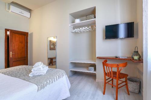 a bedroom with a bed and a chair and a tv at B&B Ulivo Gaio in San Miniato