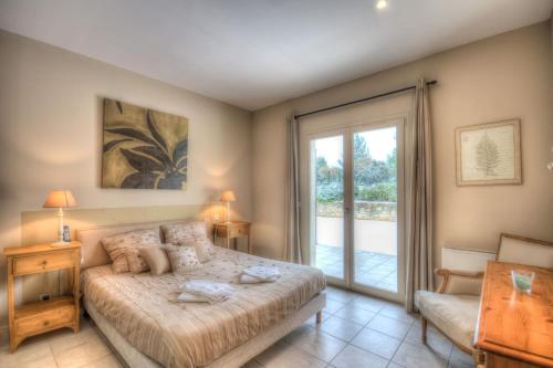 une chambre avec un lit et une porte coulissante en verre dans l'établissement Mas Santoline, à Eygalières