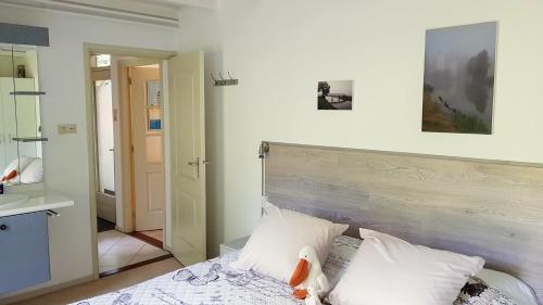 een slaapkamer met een bed met een houten hoofdeinde bij het Pelikaantje in Werkhoven
