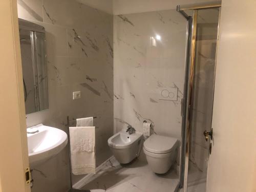 a white bathroom with a toilet and a sink at La Capannaccia - Venice in Venice