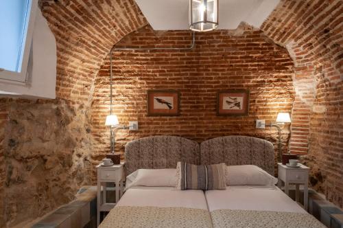 ein Schlafzimmer mit einem Bett in einer Ziegelwand in der Unterkunft Luxury Apartment museum mile. Air condicioning in Madrid