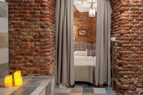 ein Schlafzimmer mit einem Bett und einer Ziegelwand in der Unterkunft Luxury Apartment museum mile. Air condicioning in Madrid