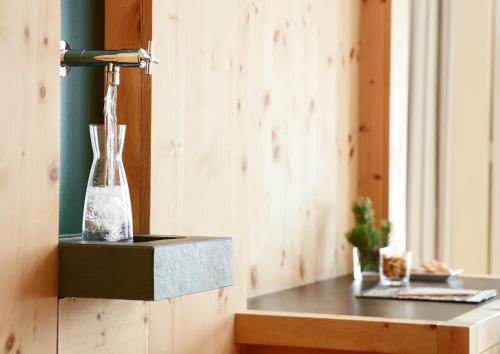 a vase on a table in a room at Arosea Life Balance Hotel in Santa Valburga St. Walburg