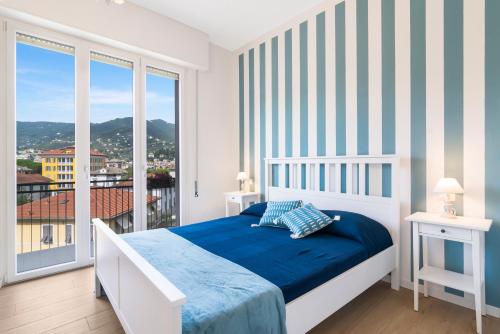 een slaapkamer met een bed en een groot raam bij Casa Babette by PortofinoHomes in Rapallo