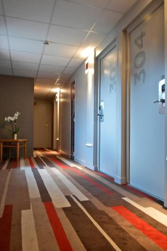 an empty corridor with a door in a building at ibis Saint Quentin Basilique in Saint-Quentin