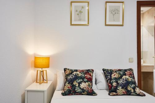 ein Schlafzimmer mit einem Bett mit zwei Kissen und einer Lampe in der Unterkunft LEEWAYS APARTMENT I in GRAN VÍA in Madrid