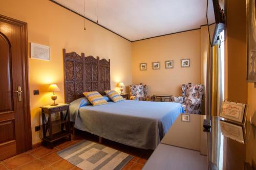 a bedroom with a bed and two chairs at Hosteria De Langre in Langre