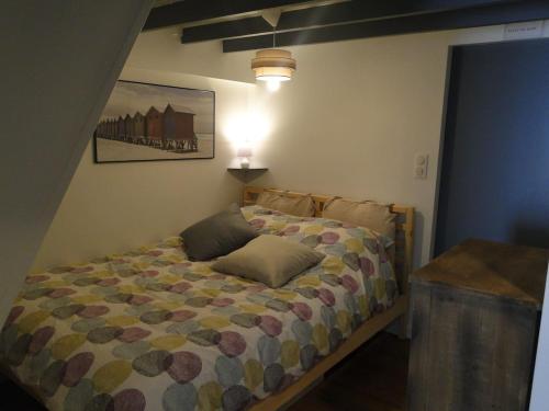 um quarto com uma cama com um candeeiro em Le Cotin em Fécamp