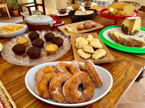 a table topped with plates of donuts and other pastries at Agriturismo Torre Ercolana in Anagni