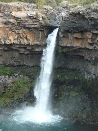 a waterfall on the side of a rocky cliff at Bosque Vivo in Recinto
