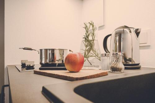 an apple on a cutting board next to a kitchen counter at Der Lederer Hof - Boutique Apartments in Tegernsee