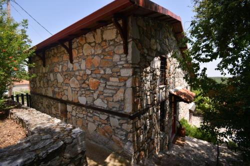 a stone building with a roof on the side of it at Stonehouse 2 Bedroom Chalet on Olympus Amazing View in Pétra