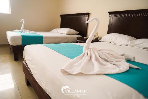 two white swans on two beds in a hotel room at Hotel Villamar in Veracruz