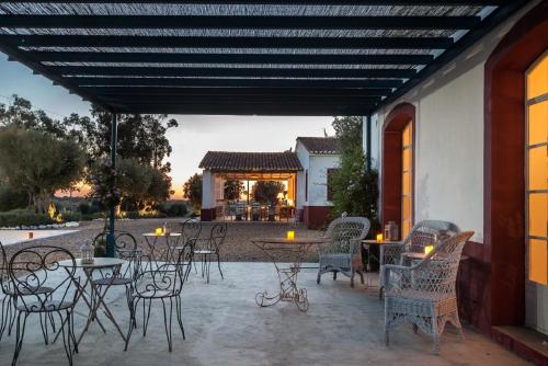a patio with tables and chairs and a building at Quinta da Chaminé in Ferreira do Alentejo