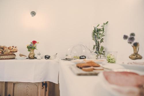 a table with a white table cloth with bread on it at Der Lederer Hof - Boutique Apartments in Tegernsee