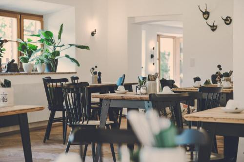 a restaurant with wooden tables and chairs and plants at Der Lederer Hof - Boutique Apartments in Tegernsee