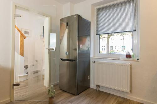 a stainless steel refrigerator in a kitchen with a window at Casa Teutoburgia in Herne