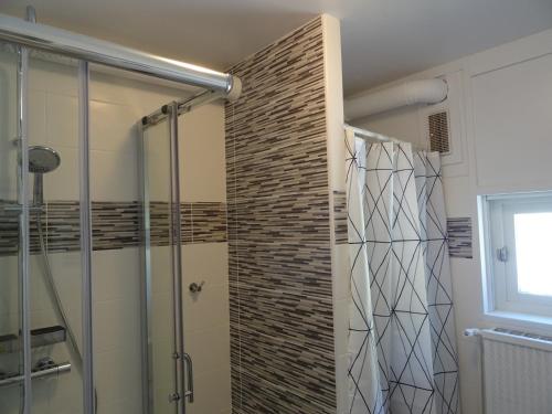 ein Badezimmer mit einer Glasdusche mit Ziegelwand in der Unterkunft T2 confort,Vue d'Exception,calme,prés des pistes in La Mongie