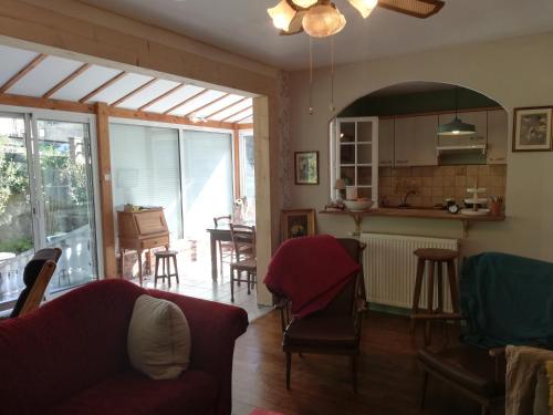 een woonkamer met een bank en een keuken bij Gîte de la Corniche in Chaumont