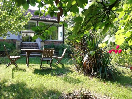 - une table et des chaises dans la cour d'une maison dans l'établissement Gîte de la Corniche, à Chaumont
