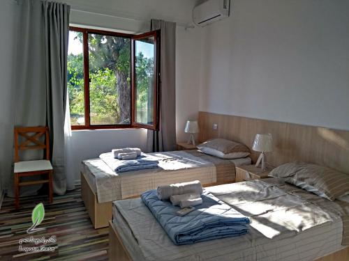 1 dormitorio con 2 camas y ventana en Hotel Lopota Gate en Napareuli