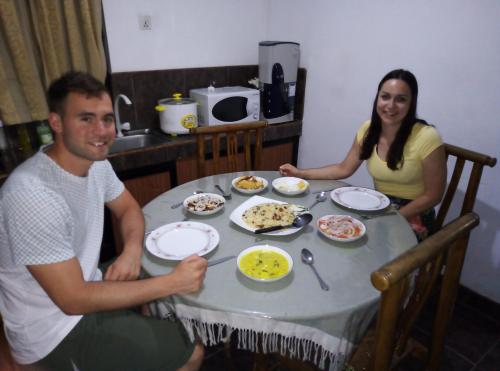 a man and a woman sitting at a table with food at Mango Roots in Gampaha